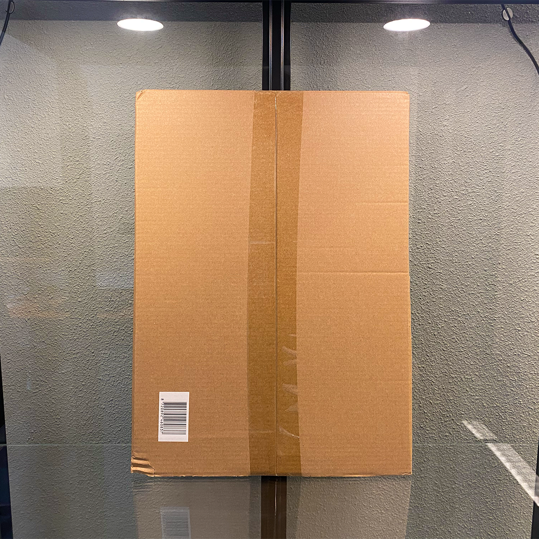 Kartonverpakking van de eerste versie van de TitanChef RVS snijplank, gefotografeerd recht van voren.