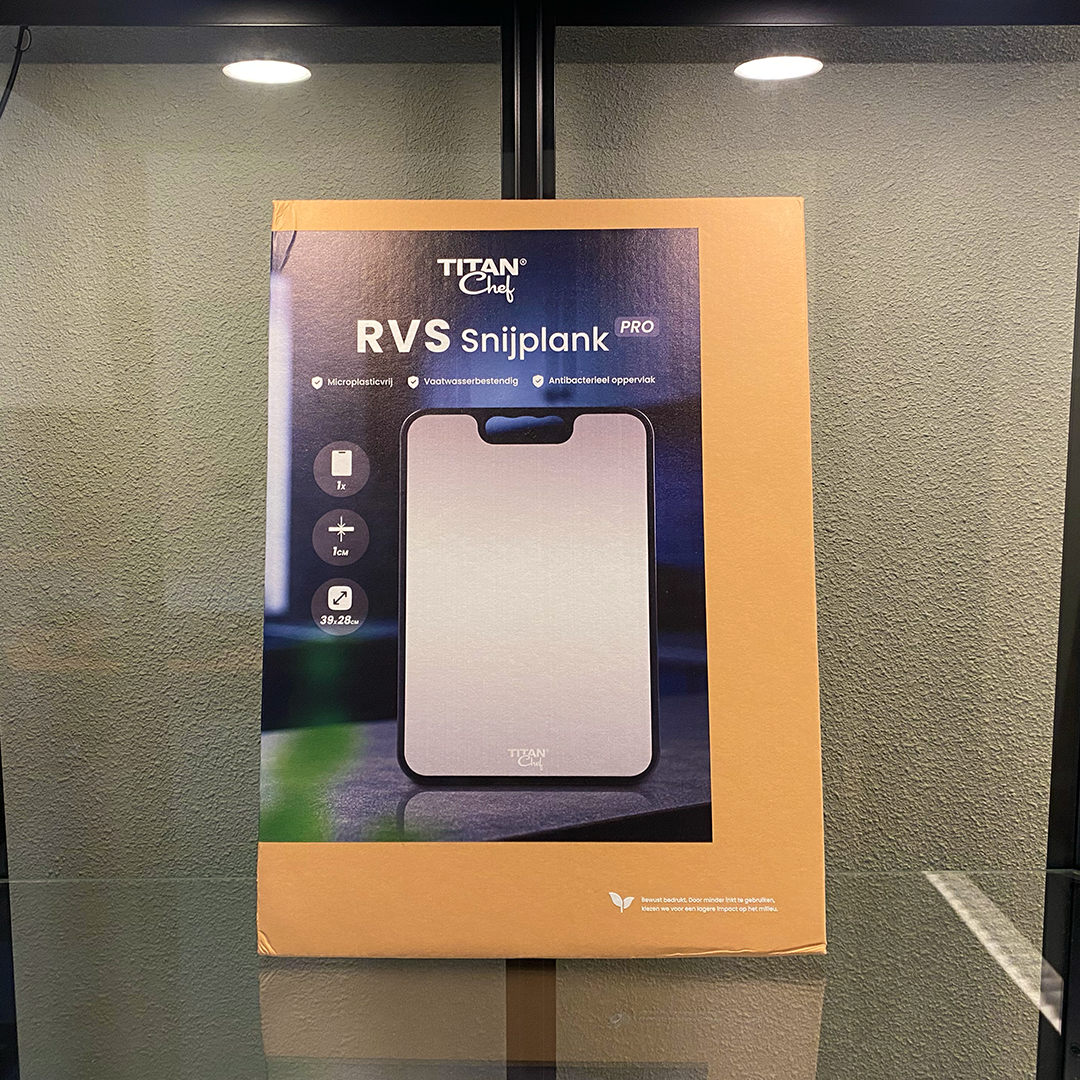 Voorkant van de TitanChef PRO RVS snijplank verpakking, met productinformatie en saprand- en antislip-iconen zichtbaar.